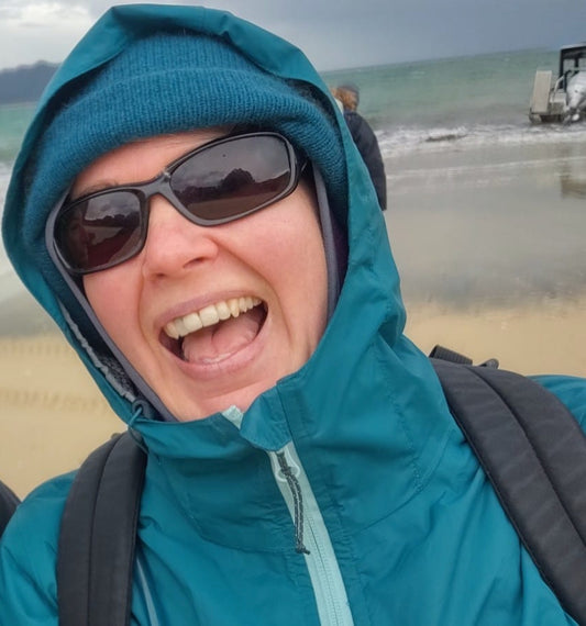 Helen Townsend on a beach wearing a woolly hat and raincoat