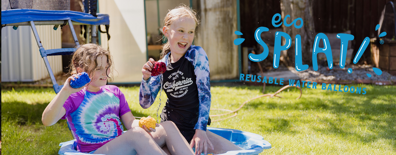 Two 10 year old girls sitting in a paddling pool in a sunny garden, laughing, throwing EcoSplat Reusable Water Balloons. Includes the EcoSplat Reusable Water Balloons logo.