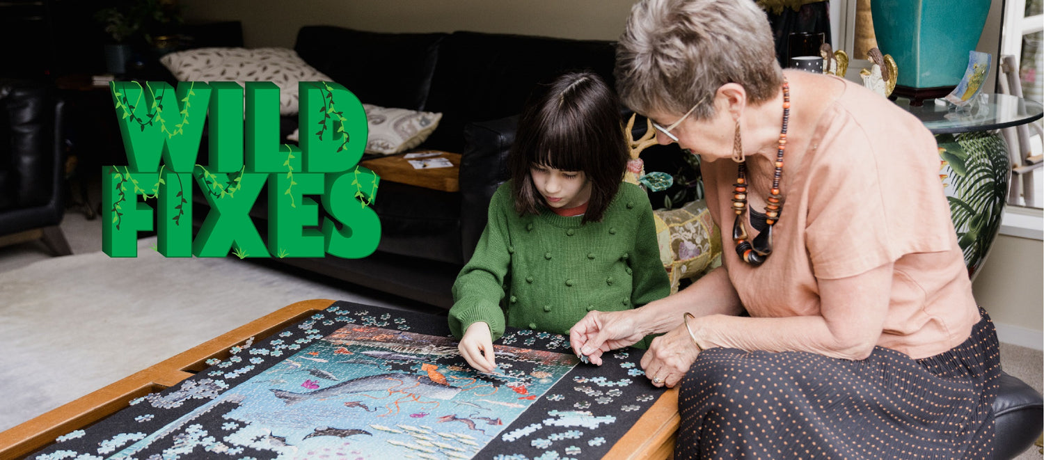 A 6 year old child and her grandmother complete the Wild Fixes jigsaw puzzle together. The puzzle shows whales. Includes the Wild Fixes logo