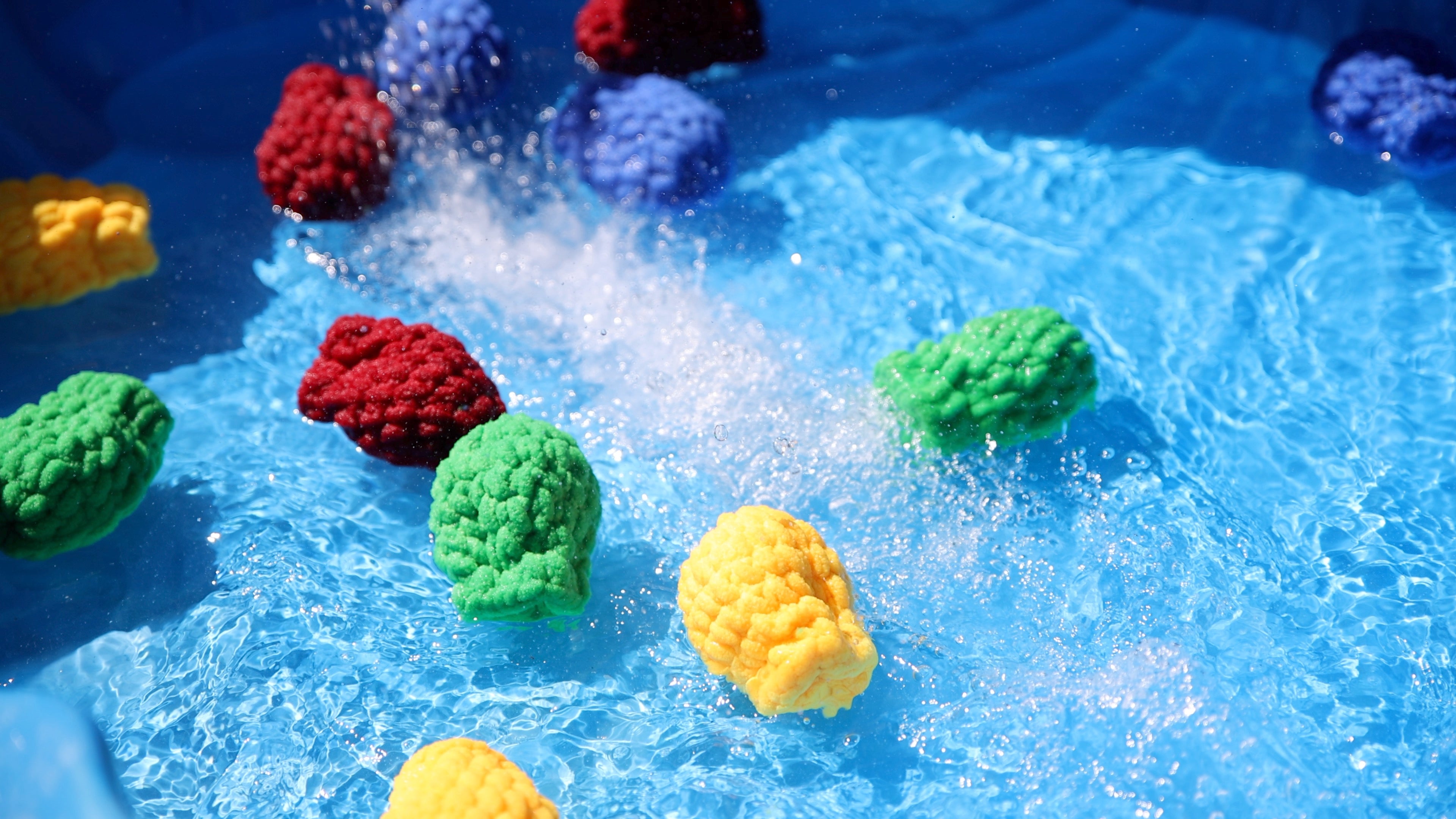 Load video: Children and adults playing with reusable water balloons in a garden